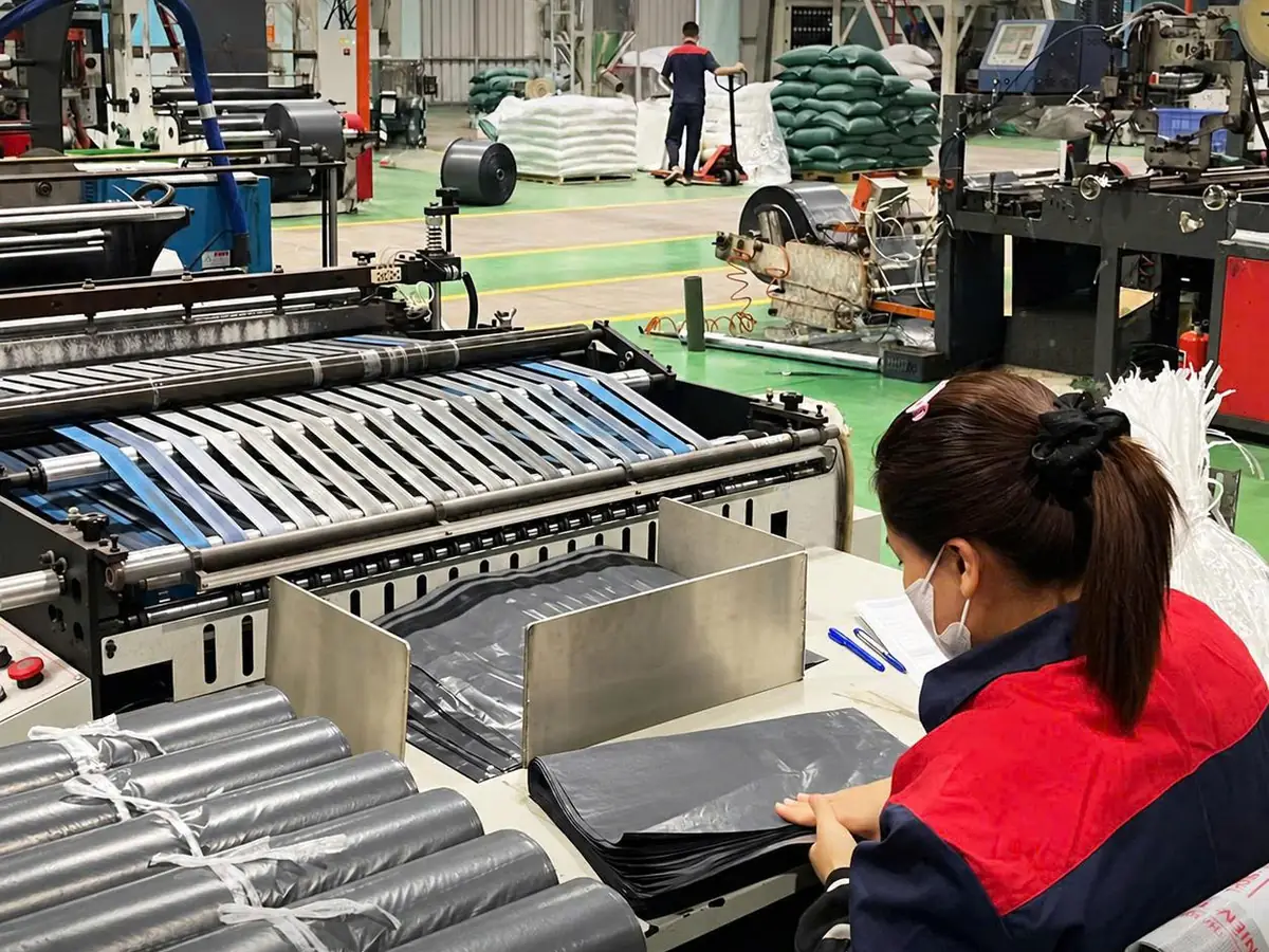 Công nhân đóng cuộn túi niêm phong tại máy